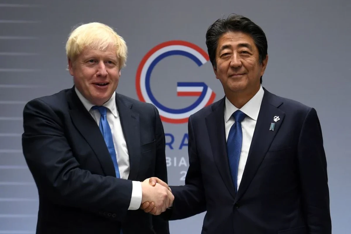 British Prime Minister Boris Johnson (L) shakes hands with Japanese Prime Minister Shinzo Abe