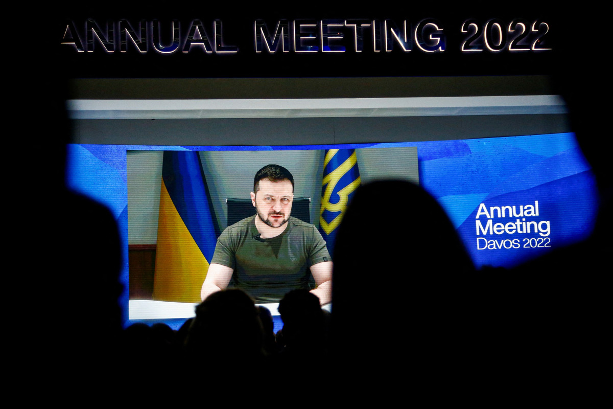 Ukraine's President Volodymyr Zelensky is seen on a screen as he delivers a video address to the delegates of the World Economic Forum (WEF) in Davos, Switzerland, on May 23