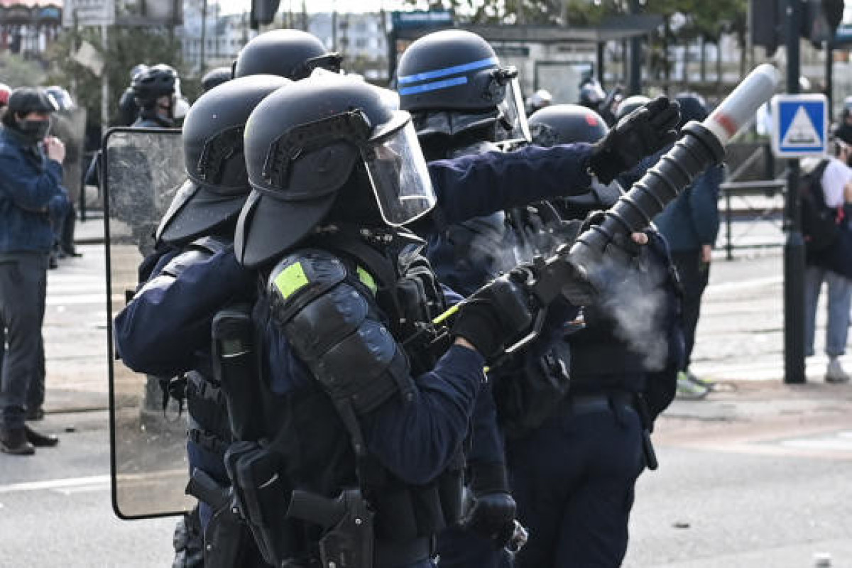 French riot police spray tear gas at wall of protesters in angry clash at tourist hotspot