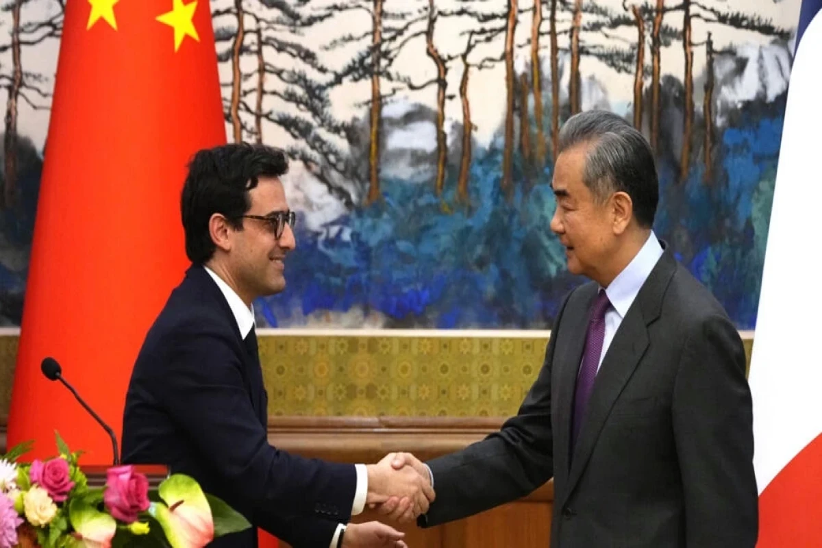 Chinese Foreign Minister Wang Yi, right, shakes hands with French Foreign Minister Stephane Sejourne