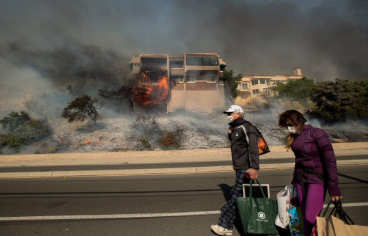 Thousands flee western Canadian town as wildfires spread