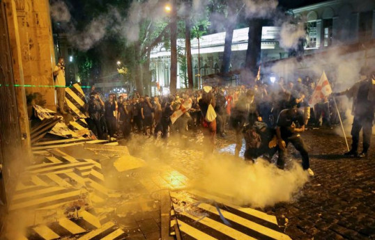 Protesters in Tbilisi toss smoke grenade into parliament building’s window