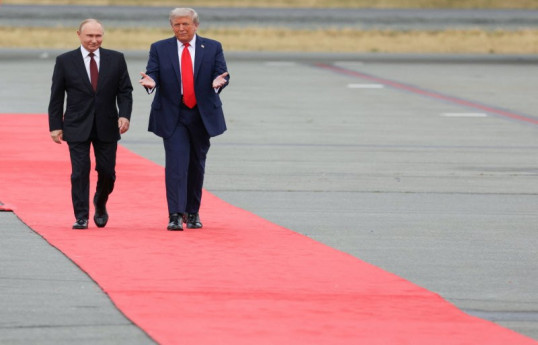Russian President Vladimir Putin and U.S. President Donald Trump walk on the tarmac after they arrived to attend a meeting at Joint Base Elmendorf-Richardson in Anchorage, Alaska, U.S., August 15, 2025.